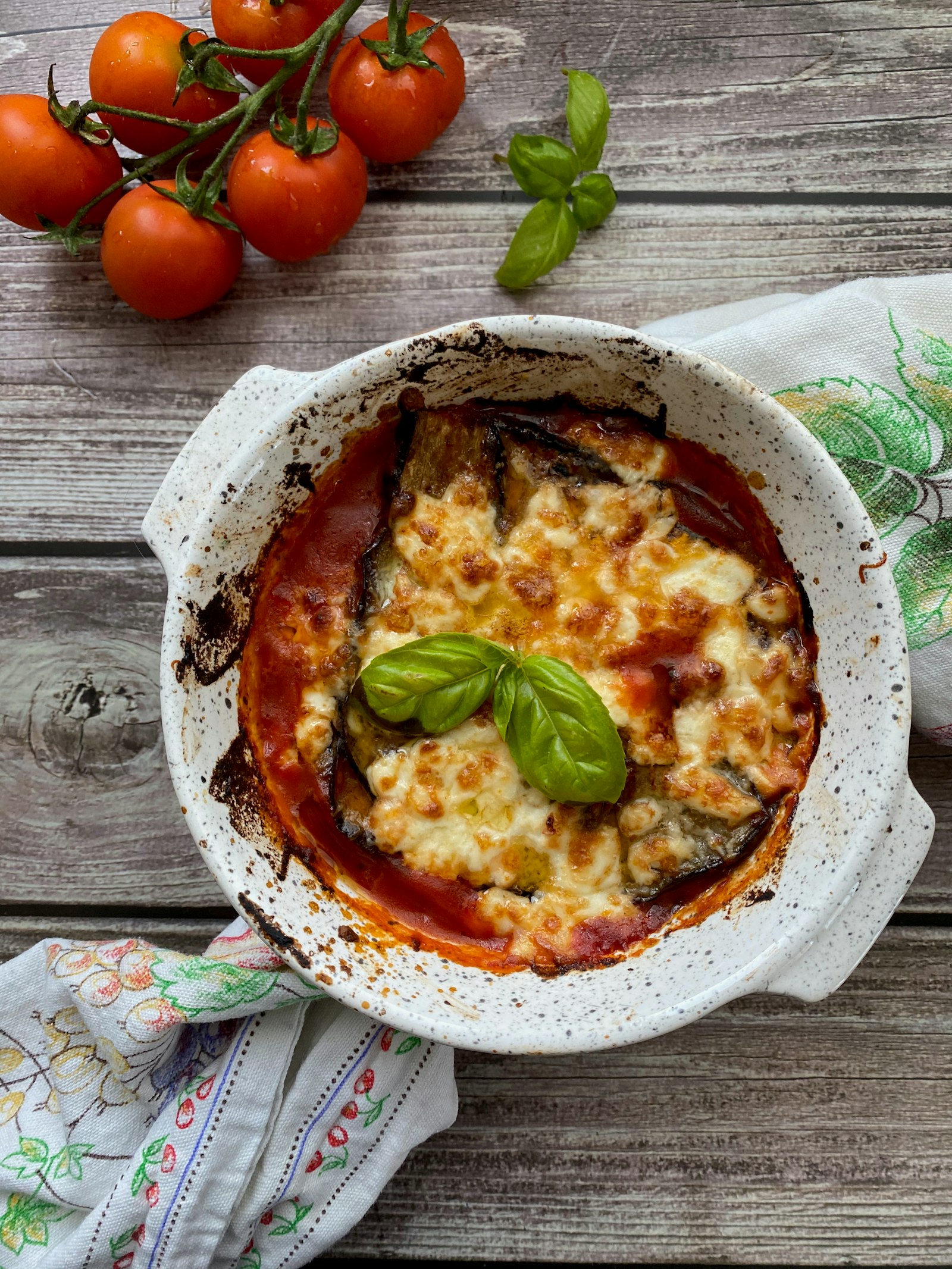 Parmigiana di melanzane in teglia con foglia di basilico