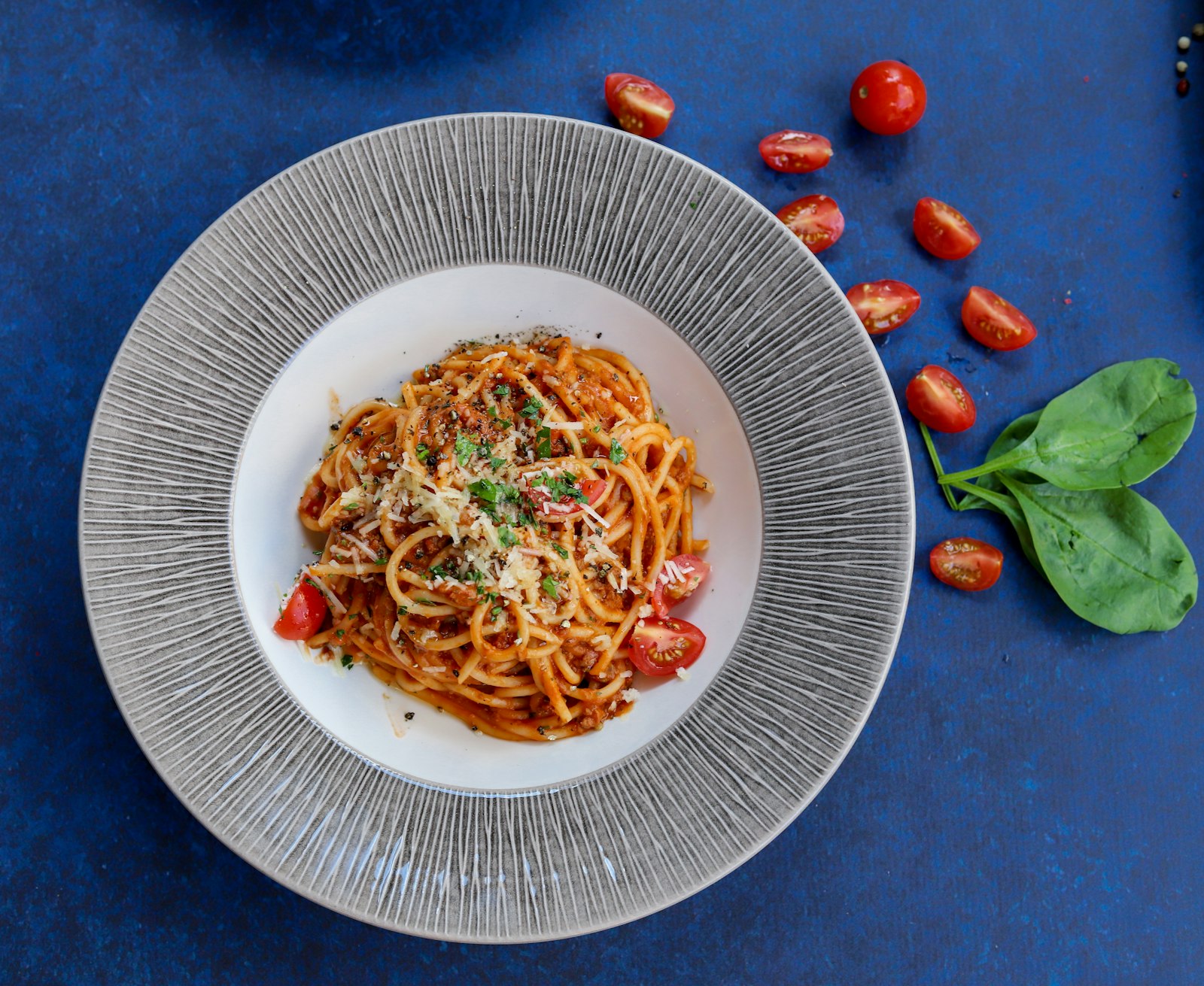 Piatto di pici conditi con sugo di pomodoro e pecorino