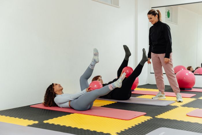 Lezione di Pilates di gruppo con esercizi su tappetino